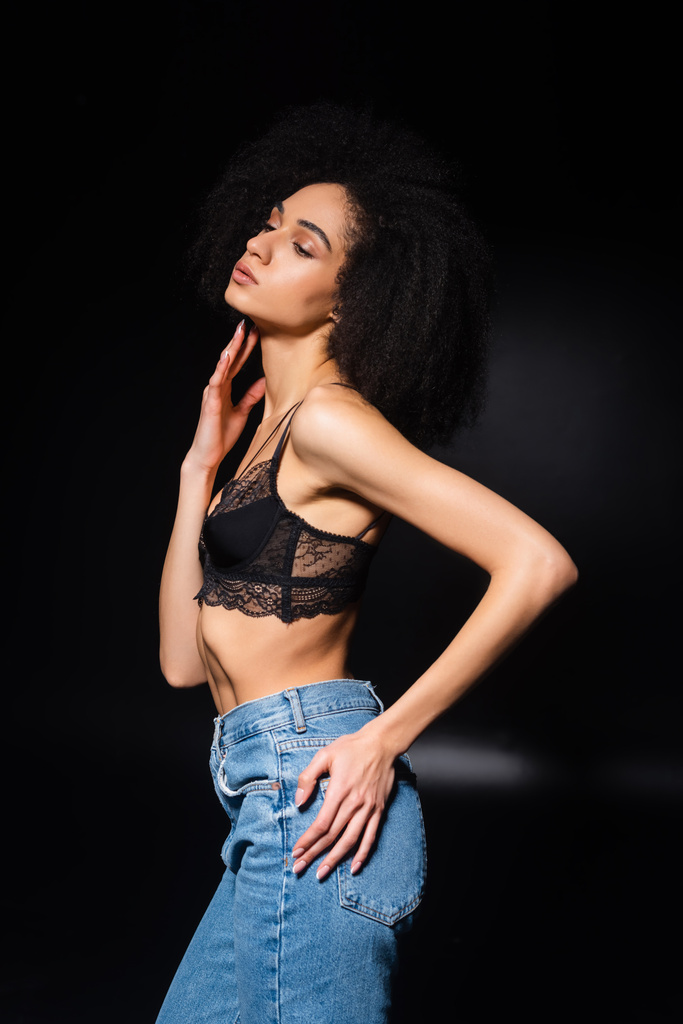 African american woman in lace bra looking away on black background  - Photo, Image