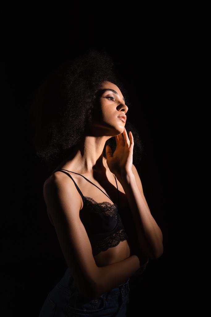 Mujer afroamericana seductora en sujetador aislado en negro  - Foto, imagen