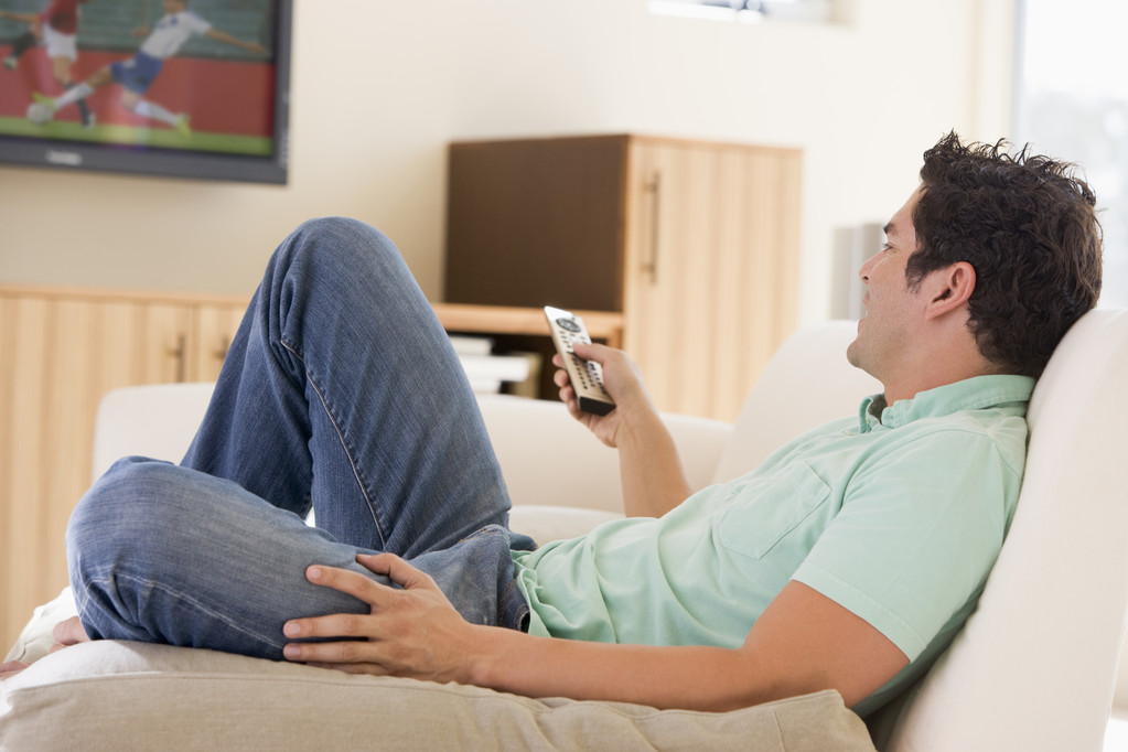 Uomo in salotto a guardare la televisione
 - Foto, immagini