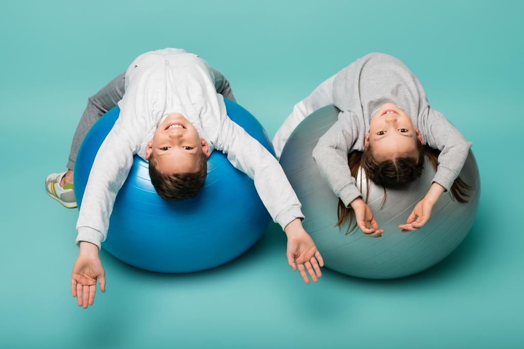 happy children in sportswear working out on fitness balls on blue - Photo, Image