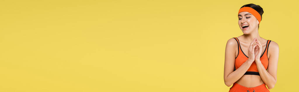 изумленная спортсменка стоящая с открытым ртом изолированная на желтом, знамя - Фото, изображение