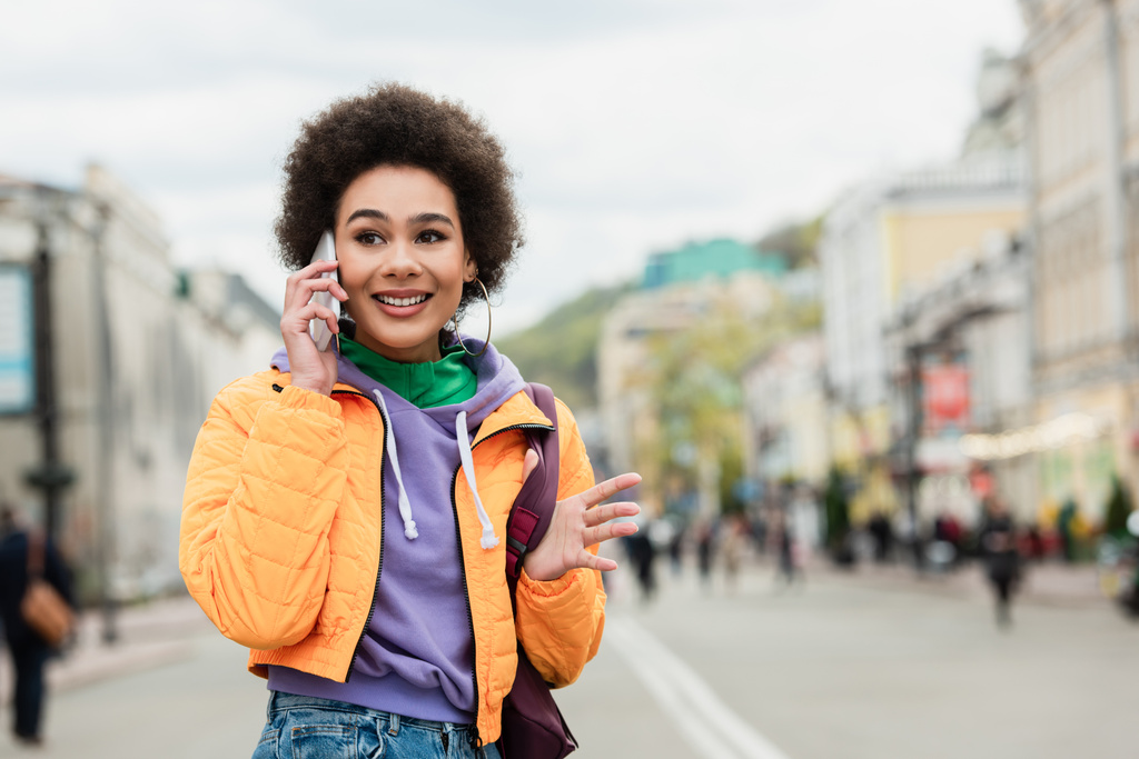 Usmívající se africká americká žena mluví na smartphone na městské ulici  - Fotografie, Obrázek