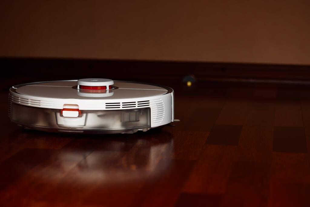 Smart Staubsaugerroboter auf Holzboden. Staubsaugerroboter führen zu einer bestimmten Zeit die automatische Reinigung der Wohnung durch. Smart home - Foto, Bild