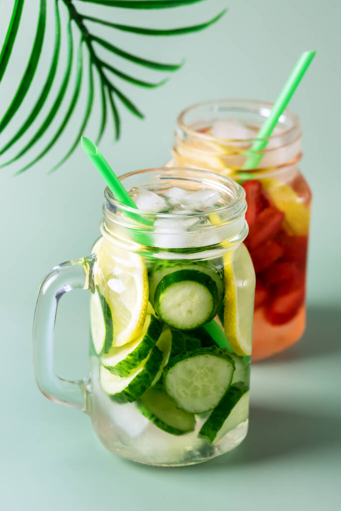 Variedade de bebidas frias de verão em frascos de vidro infundidos água de desintoxicação com limão pepino e morango Bebida saudável Fundo verde Vertical - Foto, Imagem