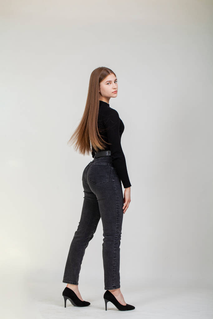 Full body portrait of a young beautiful brunette model in jeans, isolated on gray background - Photo, Image