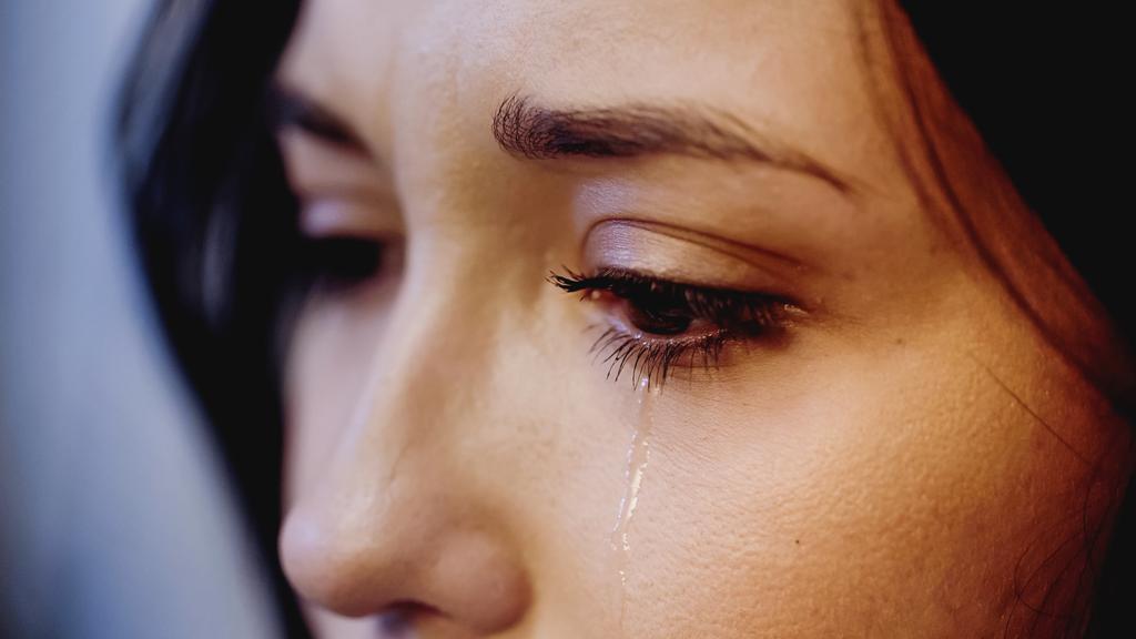 zbliżenie widok zdenerwowanej kobiety płaczącej ze łzami na twarzy na szarym tle - Zdjęcie, obraz
