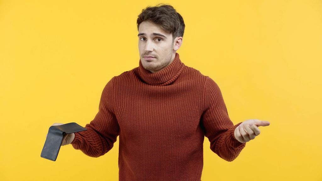 Hombre confuso en jersey con cartera aislada en amarillo  - Foto, Imagen