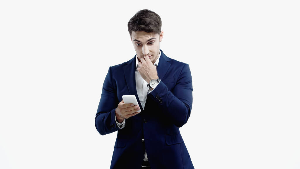 Verrast zakenman op zoek naar smartphone geïsoleerd op wit - Foto, afbeelding