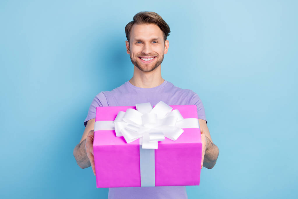 Portrait photo de l'homme souriant donnant boîte cadeau sur partie isolé sur fond de couleur bleu pastel - Photo, image