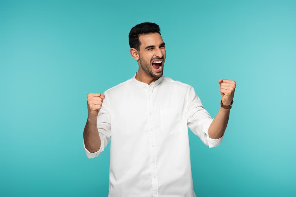 Excited arabian man showing yes gesture isolated on blue  - Foto, afbeelding