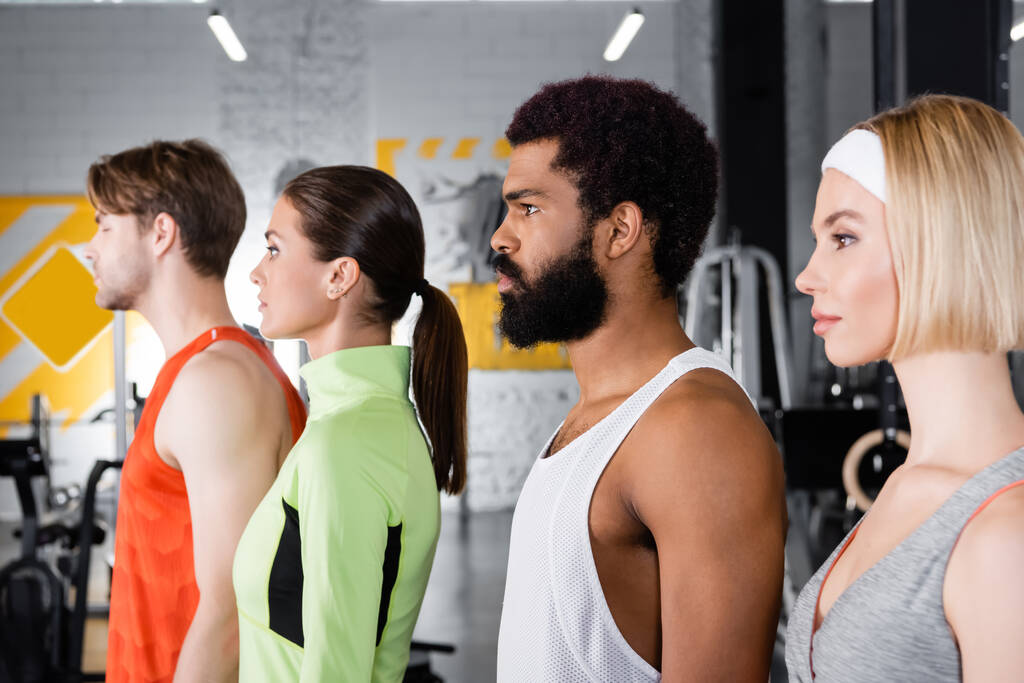 vue latérale des sportifs multiethniques debout dans la salle de gym - Photo, image