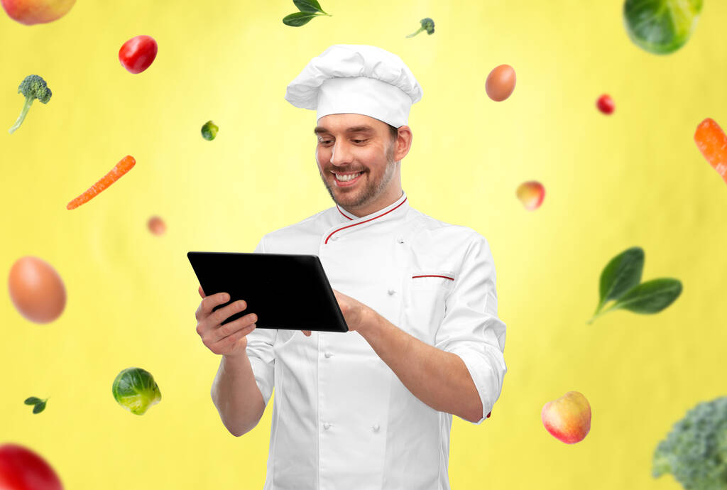 gelukkig lachende mannelijke chef-kok met tablet pc computer - Foto, afbeelding