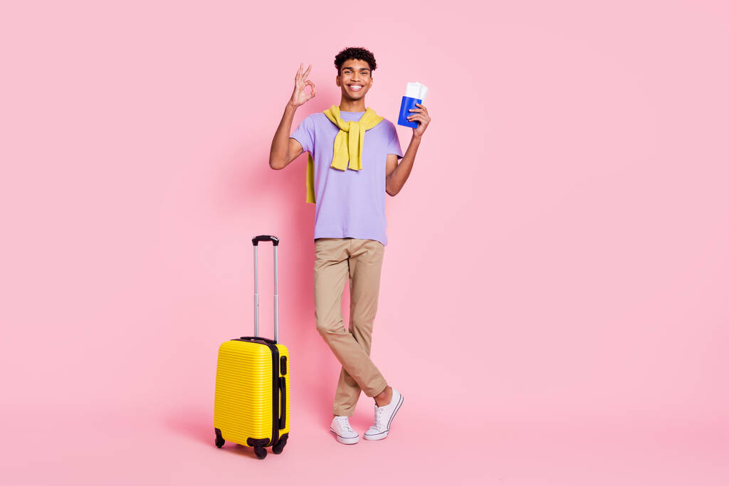 Foto de tamaño completo de joven sonriente afro hombre mostrar signo de bien celebrar entradas vacaciones de verano aislado en el fondo de color rosa - Foto, Imagen