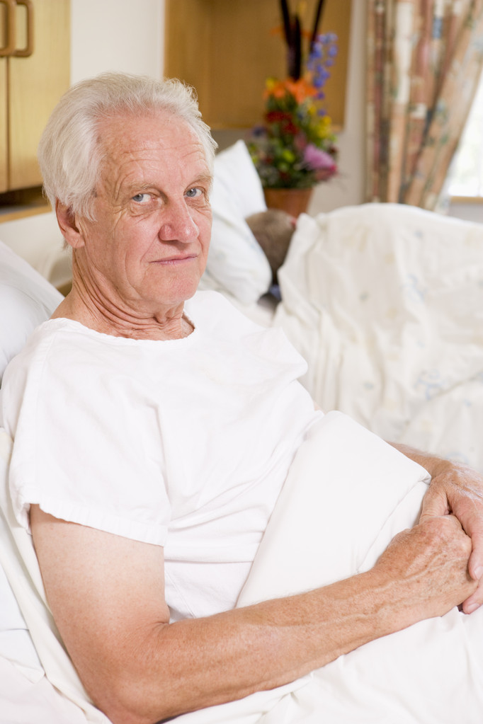 Senior férfi ül a kórházi ágyon - Fotó, kép