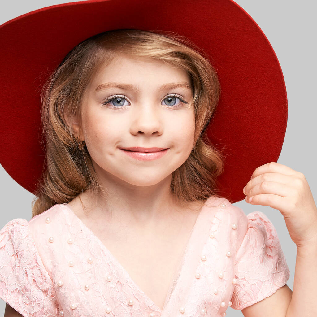 ピンクのドレスと赤い頭の小さなかわいい女の子。スタジオポートレート - 写真・画像