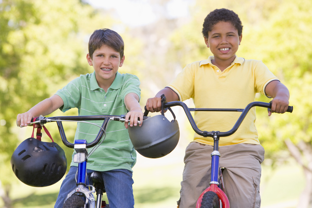 Два молодых мальчика на велосипедах на улице улыбаются
 - Фото, изображение
