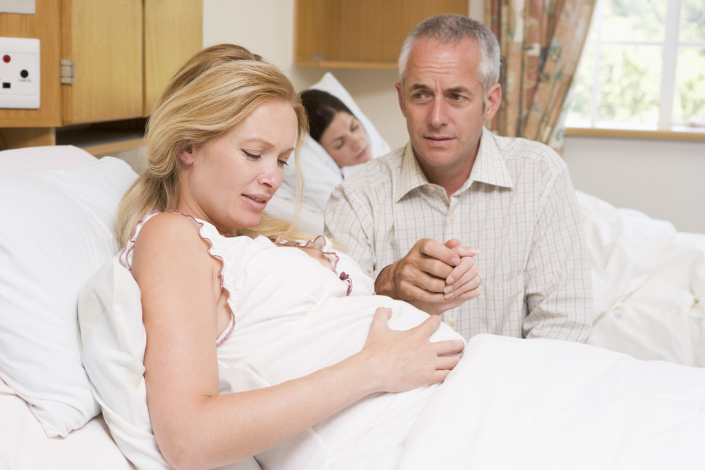 έγκυος γυναίκα στον πόνο με το σύζυγό της στο νοσοκομείο - Φωτογραφία, εικόνα