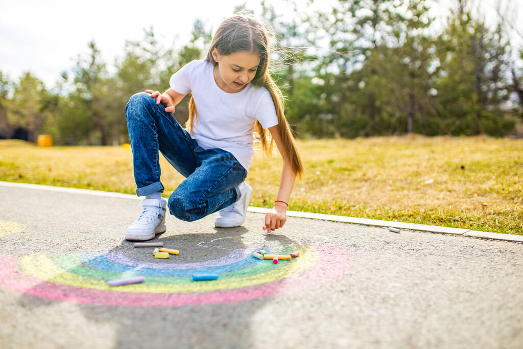 dospívající dívka kreslení duha barevné křídou na asfaltu v letní den - Fotografie, Obrázek