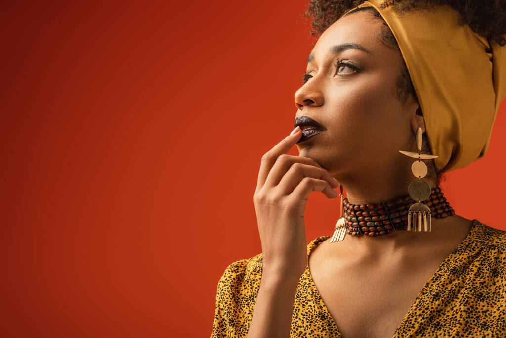 giovane donna afroamericana con rossetto labbra toccanti con dito sul rosso - Foto, immagini