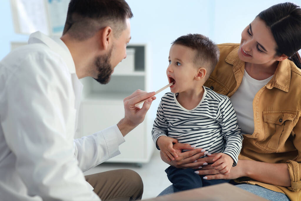 Matka a syn navštěvují pediatra v nemocnici. Doktor vyšetřuje malého chlapce - Fotografie, Obrázek