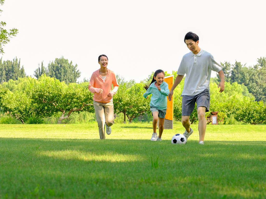 Happy family of three playing football in the park - Photo, Image