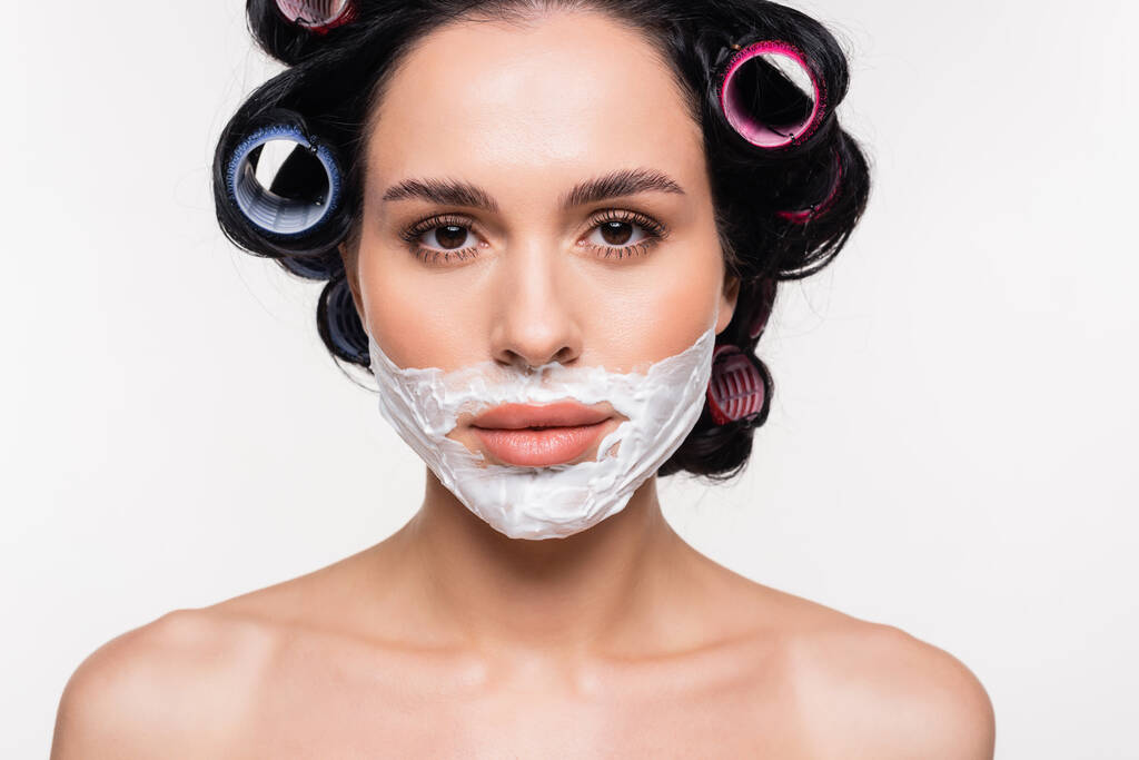 portrait of serious young woman with shaving cream on face isolated on white - Photo, Image