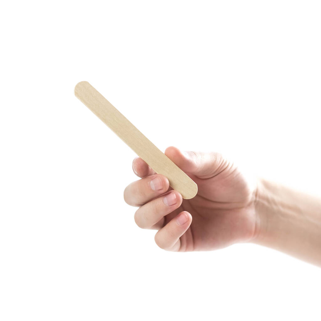 The hand holds wooden spatulas. Close up. Isolated on a white background. - Photo, Image