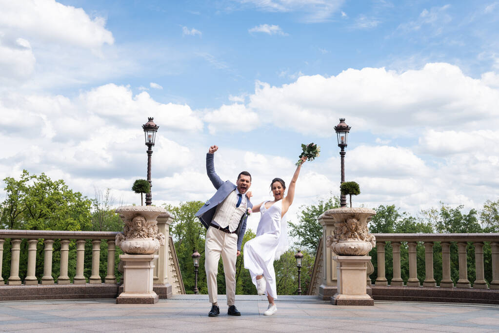 Χαρούμενος γαμπρός δείχνει ναι χειρονομία κοντά νύφη στο πάρκο  - Φωτογραφία, εικόνα