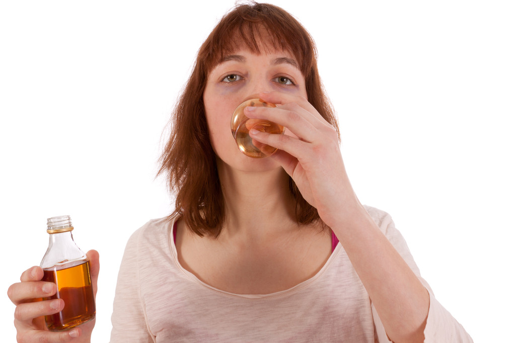 Una giovane donna sta bevendo alcolici duri e ha una bottiglia in mano
 - Foto, immagini