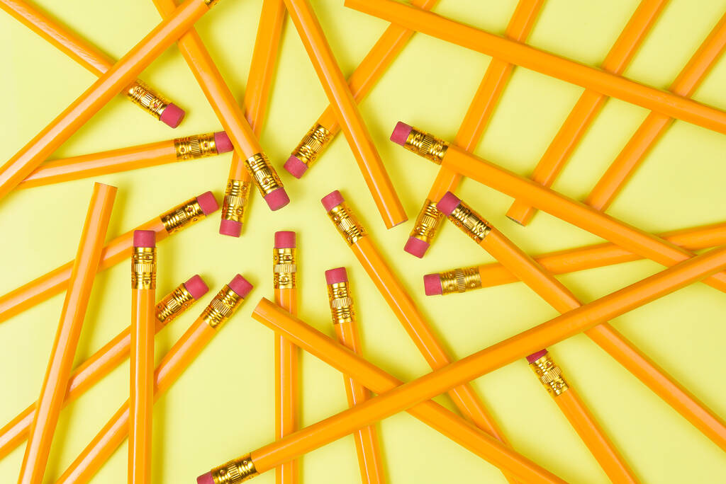 Powrót do tematu Szkoły: Widok z góry grupy ołówków na żółtym tle wypełniającym ramkę. - Zdjęcie, obraz
