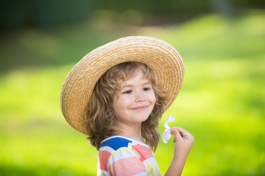Caucasian child portrait close up. Kids in straw hat with plumeria flower. - Photo, Image