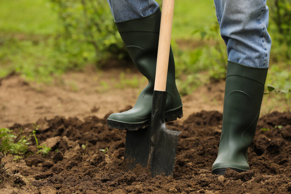 İşçi açık havada kürekle toprak kazıyor, yakın plan. Bahçe aleti - Fotoğraf, Görsel
