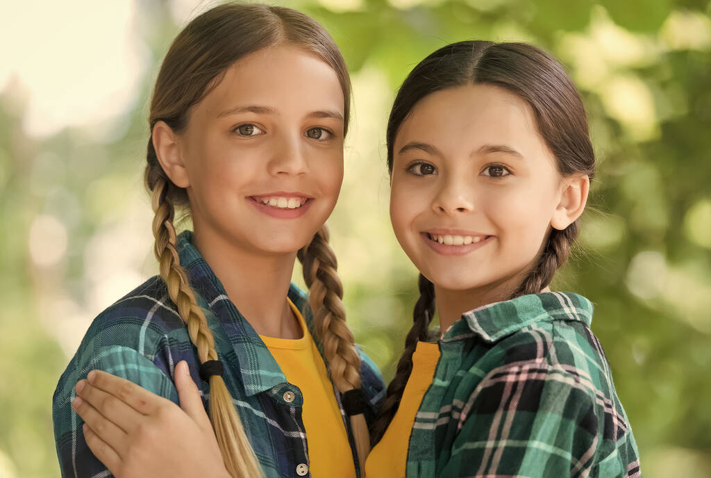 Caring environment. Happy girls in pigtails smile outdooes. Skincare products. Summer vacation. Haircare cosmetics. Beauty salon. Childcare and pediatric health care. Social care - Photo, Image