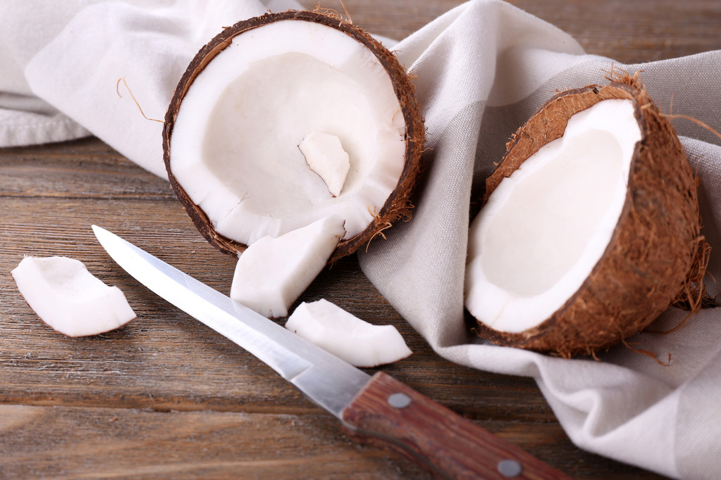 złamane kokosowe z nożem i serwetka na drewniane tła - Zdjęcie, obraz