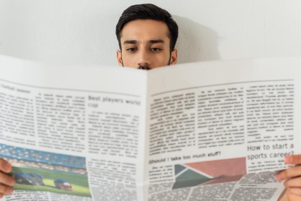 Hombre leyendo el periódico en primer plano borroso  - Foto, imagen