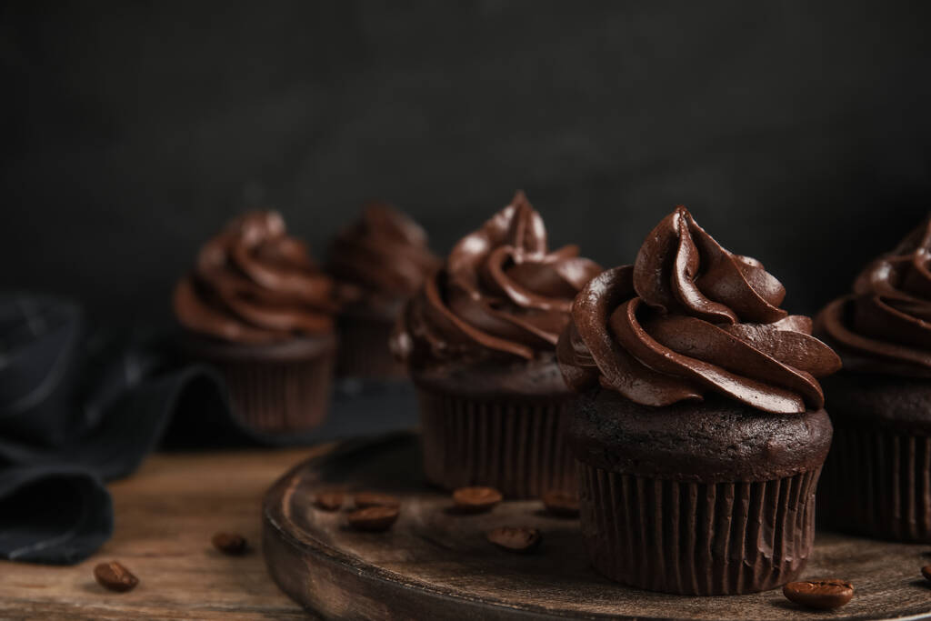 Deliciosos cupcakes de chocolate con crema en la mesa de madera. Espacio para texto - Foto, imagen