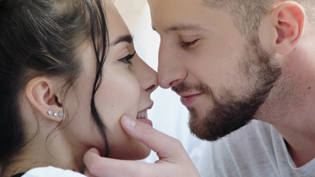 close up of bearded man touching face of happy brunette woman  - Photo, Image