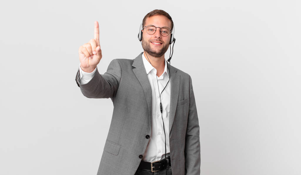 telemarketer businessman smiling and looking friendly, showing number one - Foto, Imagem
