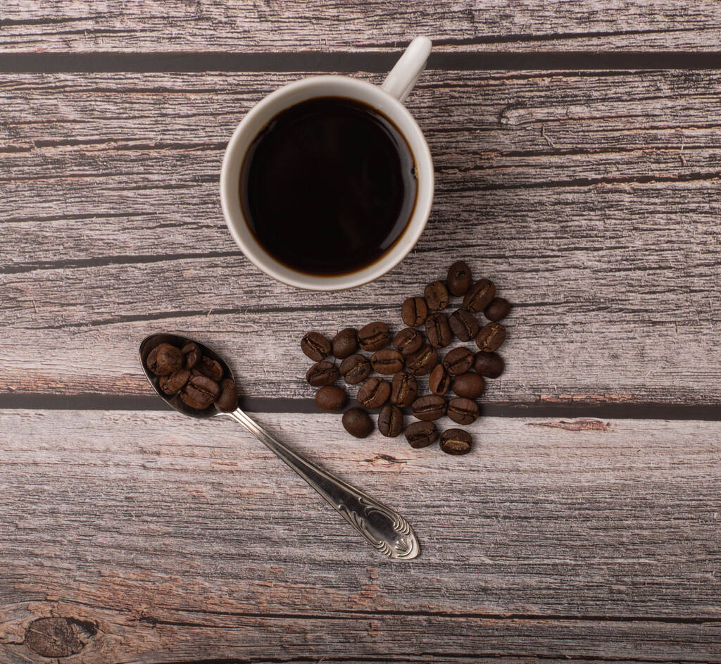 tmavá káva a zrna na dřevěném pozadí - Fotografie, Obrázek
