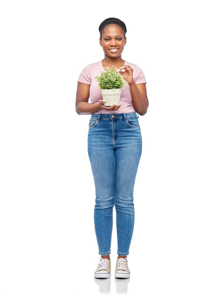 feliz sonriente mujer africana sosteniendo flor en olla - Foto, Imagen