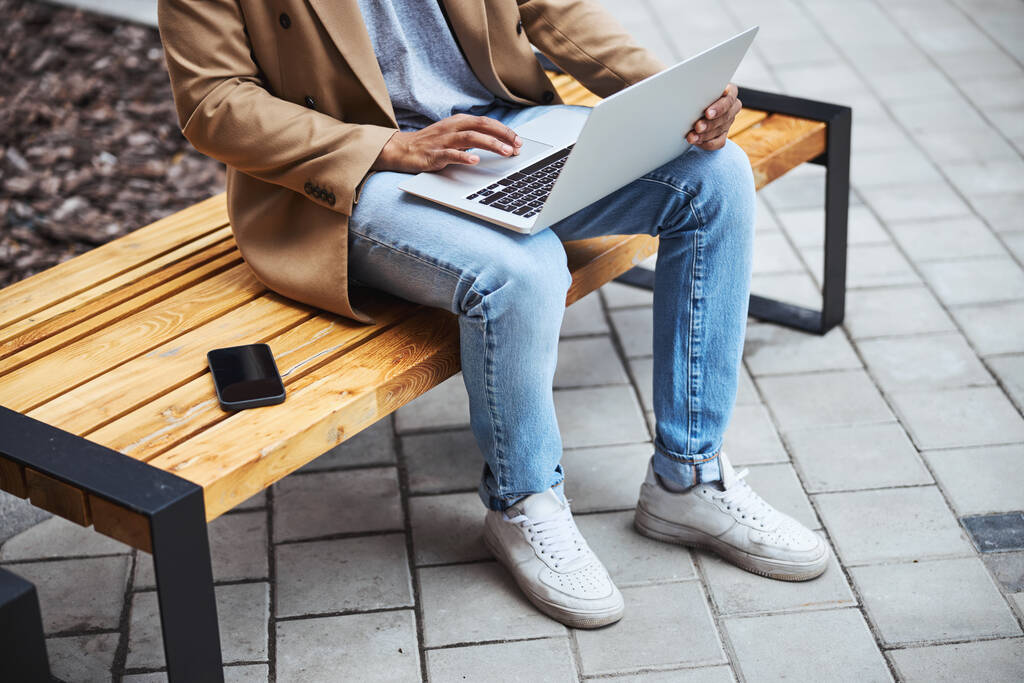 Крупним планом зайнятий чоловік використовує свій ноутбук
 - Фото, зображення