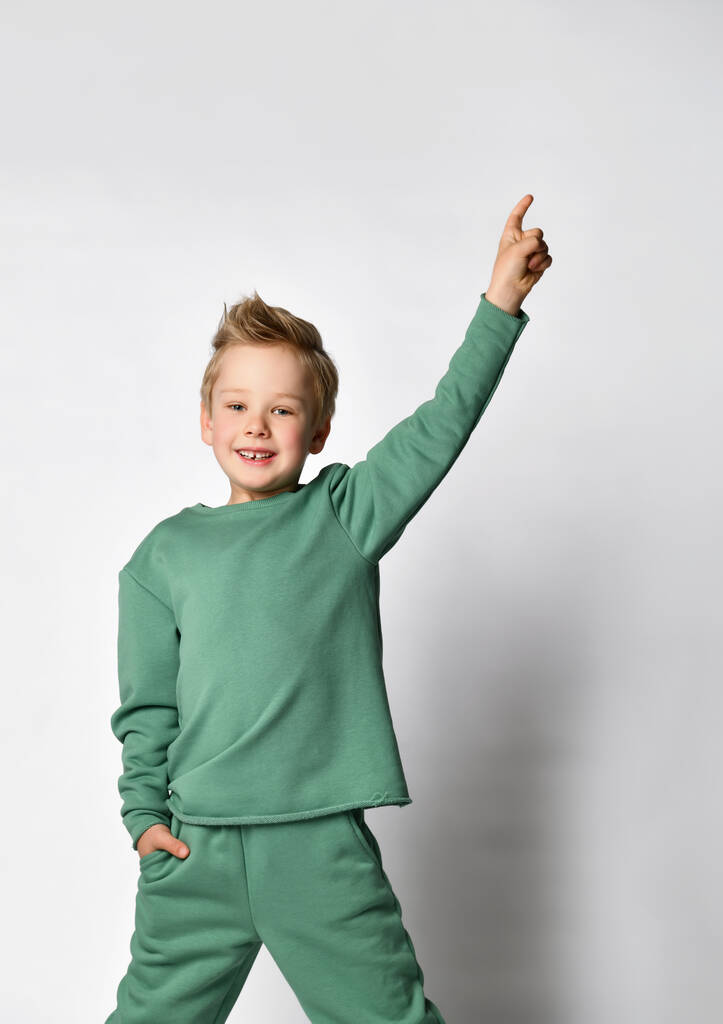 Cute little boy child with hand in pocket and one raised up dancing - Photo, Image