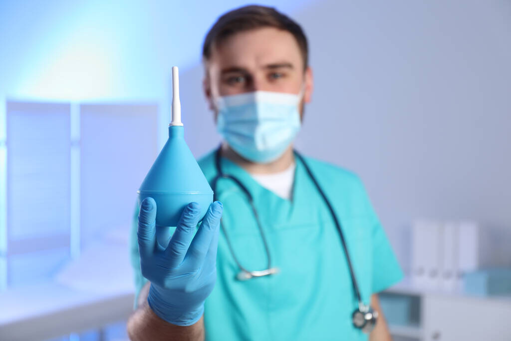 Doktor drží gumový klystýr na vyšetřovně, soustřeď se na ruce. Mezera pro text - Fotografie, Obrázek
