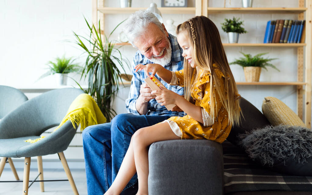 Счастливый дедушка любит проводить время смеясь с маленькой девочкой внучка дома - Фото, изображение