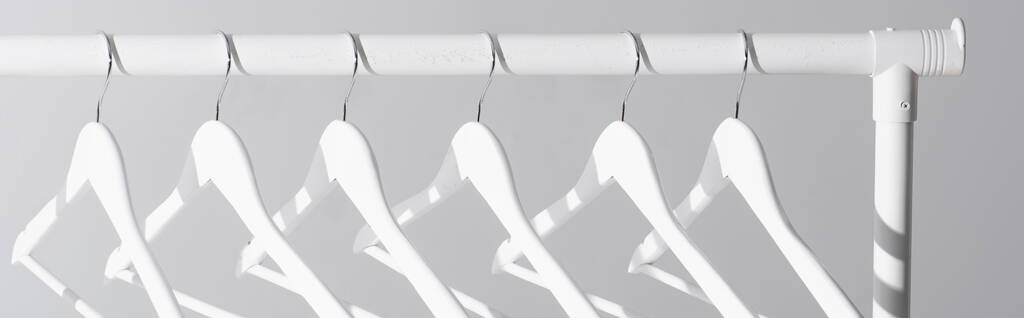 coleção de cabides brancos no rack de roupas isolado em cinza, banner - Foto, Imagem
