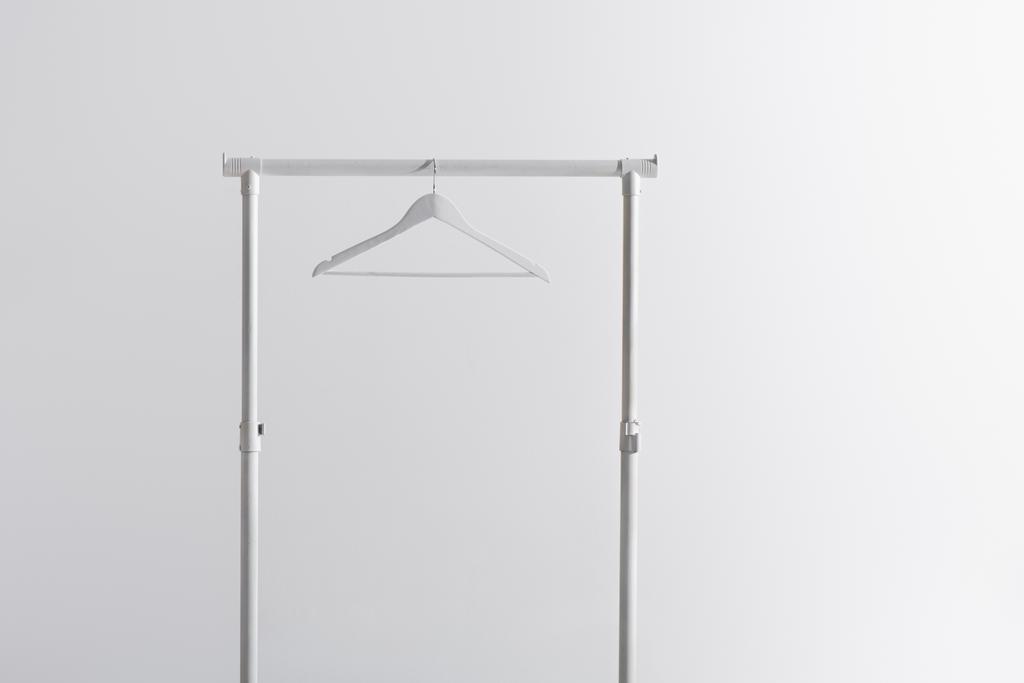weißer Kleiderbügel auf Kleiderständer isoliert auf grau - Foto, Bild