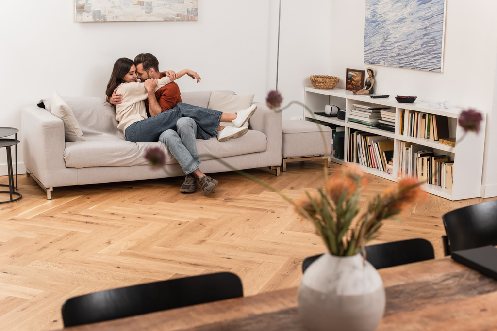 Young man hugging happy girlfriend in living room  - Photo, Image