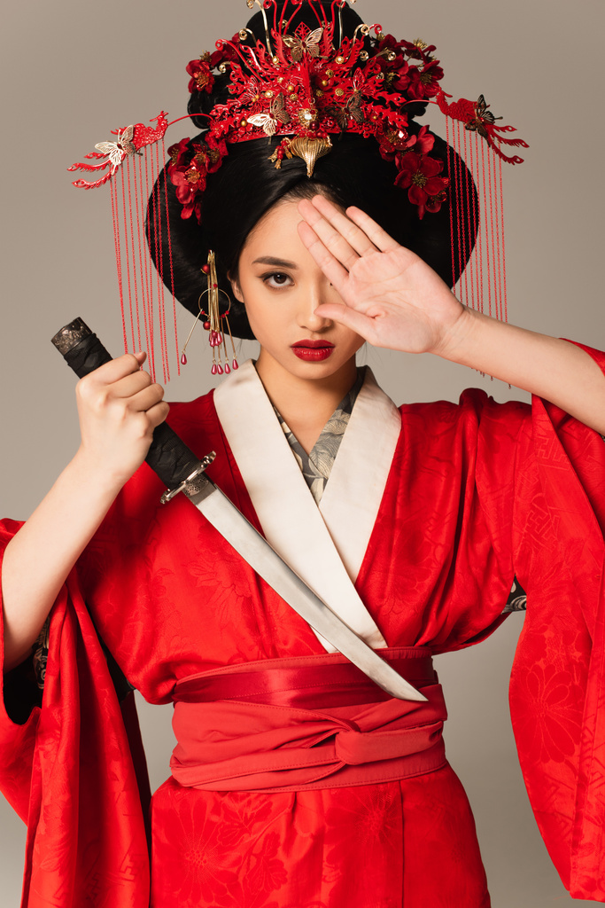 Japán nő kezében kard és fedő szem elszigetelt szürke  - Fotó, kép