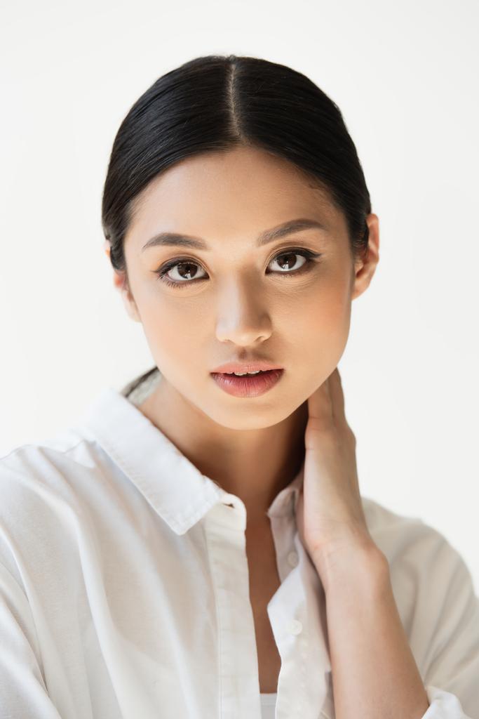 Pretty asian woman in shirt looking at camera isolated on grey - Photo, Image
