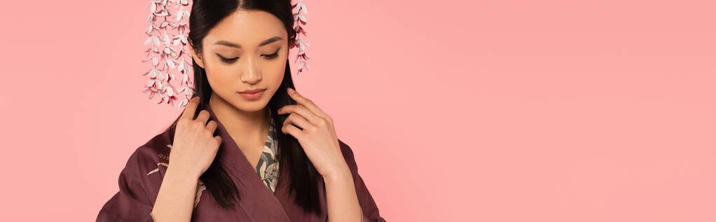 Fiatal japán nő keleti ruhák megható haj elszigetelt rózsaszín, banner  - Fotó, kép
